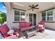 Comfortable covered patio featuring cozy seating, a ceiling fan, and a clear view of the backyard at 1961 E Stacey Rd, Gilbert, AZ 85298
