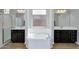 Bathroom with a soaking tub and dual vanities with dark wood cabinets at 1961 E Stacey Rd, Gilbert, AZ 85298