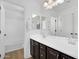 Well-lit bathroom featuring dual sinks with dark wood cabinetry, a framed mirror, and a separate shower and toilet area at 1961 E Stacey Rd, Gilbert, AZ 85298