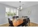 Dining room with a wooden table, black chairs, and plantation shutters at 1961 E Stacey Rd, Gilbert, AZ 85298