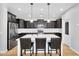 Modern kitchen with a large island, pendant lighting, stainless steel appliances, and dark cabinets at 1961 E Stacey Rd, Gilbert, AZ 85298