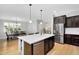 Modern kitchen with dark cabinets, hardwood floors, stainless steel appliances and a large island at 1961 E Stacey Rd, Gilbert, AZ 85298