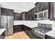 Modern kitchen featuring stainless steel appliances, dark cabinets, and a white subway tile backsplash at 1961 E Stacey Rd, Gilbert, AZ 85298
