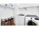 Bright laundry room with a modern washer and dryer and overhead shelving at 1961 E Stacey Rd, Gilbert, AZ 85298