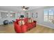 Relaxing living room with comfortable red sofa, ceiling fan, and lots of light at 1961 E Stacey Rd, Gilbert, AZ 85298