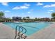 Full shot of outdoor community pool with lap lanes, seating, umbrellas, and a nearby playground at 1961 E Stacey Rd, Gilbert, AZ 85298