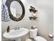 This stylish powder room features a unique mirror, decorative shelves and modern fixtures at 1961 E Stacey Rd, Gilbert, AZ 85298