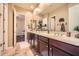 Well-lit bathroom with double sinks, dark wood cabinets and tile flooring at 2059 W Whisper Rock Trl, Phoenix, AZ 85085