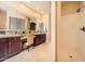 Serene primary bathroom with double sinks, dark wood cabinets, a vanity area, and glass block window accents at 2059 W Whisper Rock Trl, Phoenix, AZ 85085