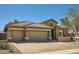 Home showcasing a three-car garage, stone accents, tile roof, and desert landscaping at 2059 W Whisper Rock Trl, Phoenix, AZ 85085