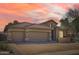 Home showcasing a three-car garage, stone accents, tile roof, and desert landscaping at dusk at 2059 W Whisper Rock Trl, Phoenix, AZ 85085