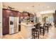 Gourmet kitchen with dark wood cabinetry, stainless steel appliances, and a center island with seating at 2059 W Whisper Rock Trl, Phoenix, AZ 85085