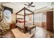 Luxurious main bedroom features a four-poster bed, tray ceiling, wood floors, and lots of natural light at 2059 W Whisper Rock Trl, Phoenix, AZ 85085