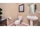 Classic powder room with a pedestal sink, round mirror and neutral decor at 2059 W Whisper Rock Trl, Phoenix, AZ 85085