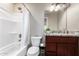Modern bathroom with a vanity featuring a granite countertop and bathtub with shower at 2644 E Sylvia St, Phoenix, AZ 85032