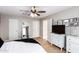 Well-lit bedroom with modern furnishings, a ceiling fan, a full-length mirror, and a dresser with a TV at 2644 E Sylvia St, Phoenix, AZ 85032