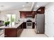 Well-equipped kitchen with stainless steel appliances, granite counters, and dark wood cabinetry at 2644 E Sylvia St, Phoenix, AZ 85032