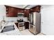 Stylish kitchen with stainless steel appliances and granite counters with sleek cherry wood cabinets at 2644 E Sylvia St, Phoenix, AZ 85032