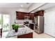 Modern kitchen features stainless steel appliances, granite counters, and sleek cherry wood cabinets at 2644 E Sylvia St, Phoenix, AZ 85032