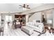 Bright living room featuring a white sofa, ottoman, ceiling fan, and open access to kitchen and dining areas at 2644 E Sylvia St, Phoenix, AZ 85032