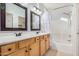 Bathroom with dual sinks, wood cabinets, and shower over tub and white shower curtain at 2656 E Longhorn Pl, Chandler, AZ 85286