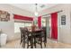 Cozy dining area with dark wood table, seating for six, red curtains, and sliding glass door at 2656 E Longhorn Pl, Chandler, AZ 85286