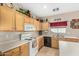 Kitchen showcasing light wood cabinets, white appliances, tile flooring, and ample countertop space at 2656 E Longhorn Pl, Chandler, AZ 85286
