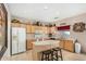 Functional kitchen features a central island with barstools, white appliances, and ample cabinet space at 2656 E Longhorn Pl, Chandler, AZ 85286