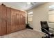 Bedroom featuring built-in cabinetry, a desk, and a view of the window at 26735 N 127Th Dr, Peoria, AZ 85383