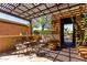 Charming covered patio area with comfortable seating, lush plants, and patterned shade at 26735 N 127Th Dr, Peoria, AZ 85383