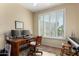 Bright home office featuring a wood desk with dual monitors and a large window with plantation shutters at 26735 N 127Th Dr, Peoria, AZ 85383
