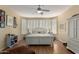 Bright main bedroom with bay window, plantation shutters, and ceiling fan at 26735 N 127Th Dr, Peoria, AZ 85383
