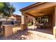 Beautiful covered patio with an outdoor kitchen, built-in grill, and dining area for entertaining at 26735 N 127Th Dr, Peoria, AZ 85383