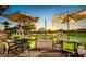 Inviting outdoor patio with seating and tables, ideal for relaxing or entertaining with sunset views at 26735 N 127Th Dr, Peoria, AZ 85383