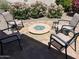 This cozy patio features a fire pit surrounded by four cushioned chairs, creating a perfect spot for outdoor relaxation at 26735 N 127Th Dr, Peoria, AZ 85383