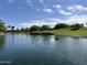 A scenic view of a golf course pond with clear water and lush landscaping at 26735 N 127Th Dr, Peoria, AZ 85383