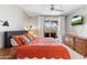Inviting bedroom showcasing neutral walls, light carpet, balcony access, ceiling fan, and a mounted television at 29606 N Tatum Blvd # 128, Cave Creek, AZ 85331