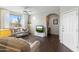 Comfortable living room with wood floors, large window with white curtains, and arched doorway to office space at 29606 N Tatum Blvd # 128, Cave Creek, AZ 85331