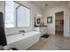 Luxurious bathroom featuring a freestanding tub, herringbone floors, and lots of natural light at 3015 W Irvine Rd, Phoenix, AZ 85086