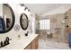 Bright bathroom featuring a dual sink vanity and a frameless glass shower with patterned tiles at 4152 N Signal Cir, Mesa, AZ 85215