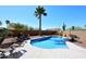 Backyard pool surrounded by desert landscaping and a tall palm tree is perfect for relaxing and enjoying the Arizona weather at 4152 N Signal Cir, Mesa, AZ 85215