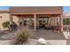 Backyard with covered patio, grill, and desert landscaping with a view of lake at 41960 W Ellington Ln, Maricopa, AZ 85138
