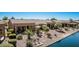 Beautiful backyard view features patio with umbrella, lake, desert landscaping, and relaxing lounge chairs at 41960 W Ellington Ln, Maricopa, AZ 85138