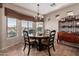 Elegant dining room with a chandelier, large windows, and a stylish dining table at 41960 W Ellington Ln, Maricopa, AZ 85138