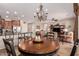 Open-concept dining area with a chandelier, seamlessly connecting to the kitchen and living room at 41960 W Ellington Ln, Maricopa, AZ 85138