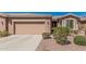 Front exterior featuring a two-car garage, well-manicured landscaping, and a welcoming entrance at 41960 W Ellington Ln, Maricopa, AZ 85138