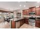 Open kitchen featuring granite countertops, stainless steel appliances, and a cozy dining area at 41960 W Ellington Ln, Maricopa, AZ 85138