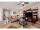 Comfortable living room with plush sofas, tile floors, a ceiling fan, and a large TV at 41960 W Ellington Ln, Maricopa, AZ 85138