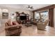 Cozy living room with comfortable sofas, a ceiling fan, and large windows overlooking the patio at 41960 W Ellington Ln, Maricopa, AZ 85138