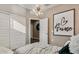 Cozy bedroom features a stylish chandelier, 'Je t'aime' wall art, and bright closet at 4927 S 106Th Ave, Tolleson, AZ 85353